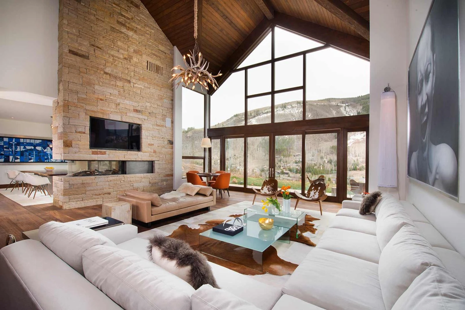 Great room with a stone fireplace and tall windows
